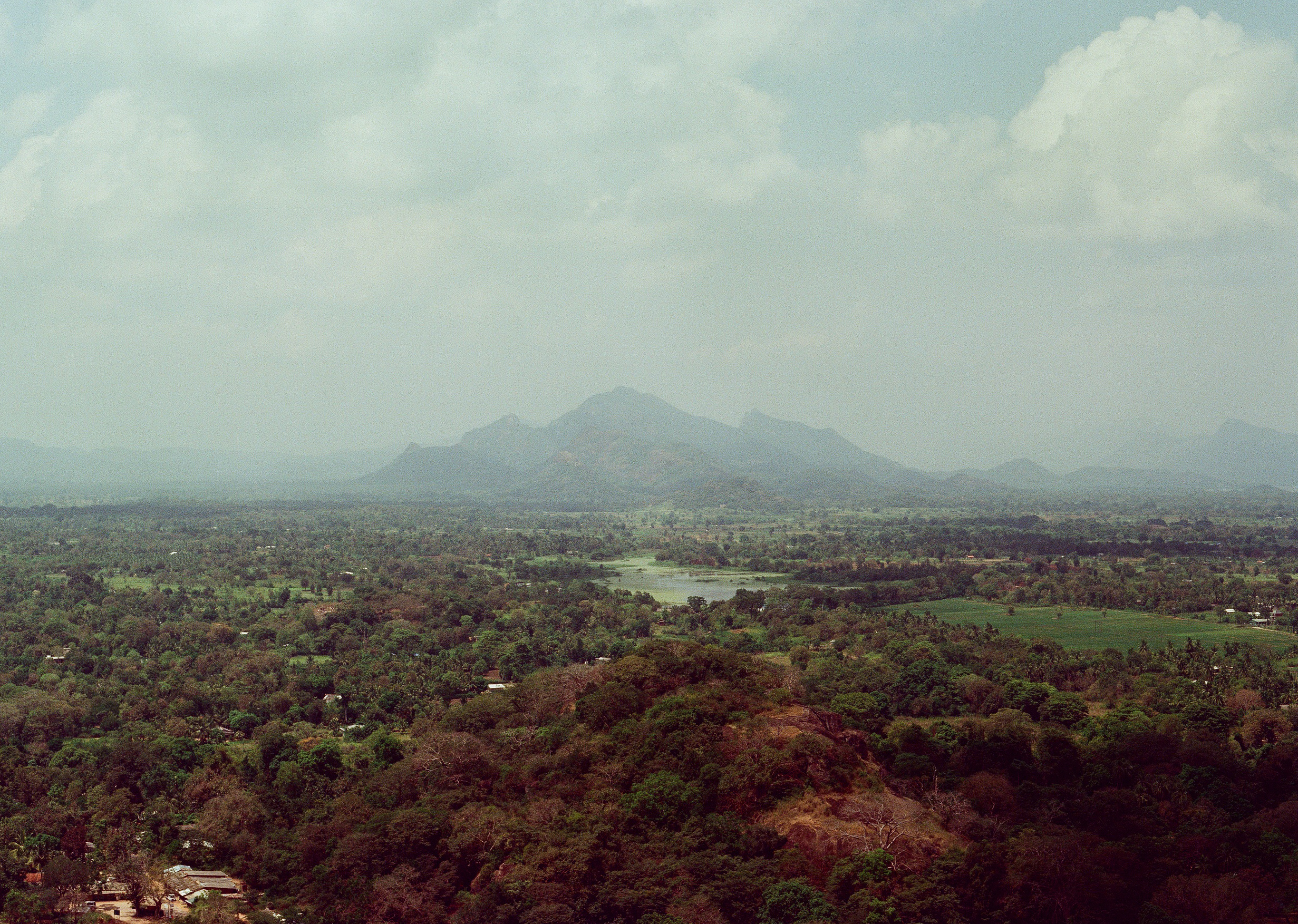 Hazy mountain peaks above a broad green landscape
