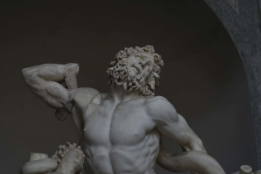 Classical marble statue beneath a dark arch